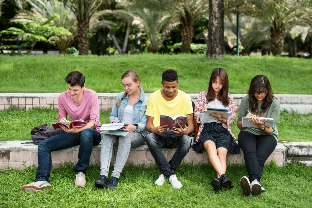 Grupo de estudiantes leyendo y compartiendo conocimientos para desarrollar disciplina y trabajo en equipo.