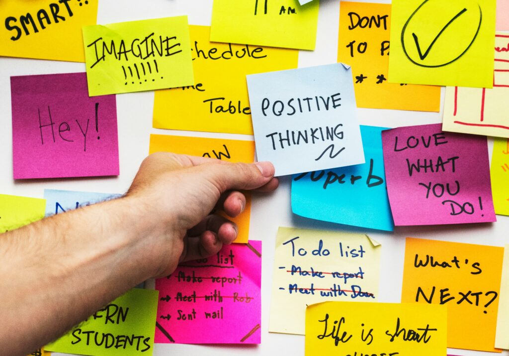 Pared cubierta con notas adhesivas (post-its) de colores para una sesión de lluvia de ideas y organización del pensamiento.