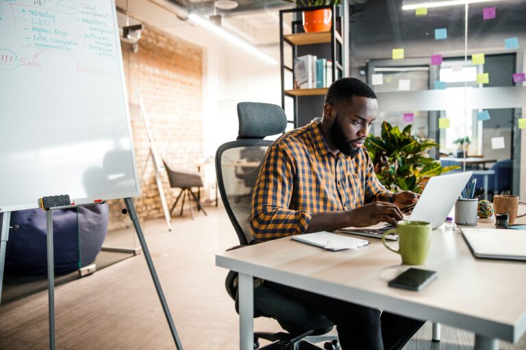 Hombre trabajando de forma enfocada en el computador para mantener la constancia en sus proyectos.