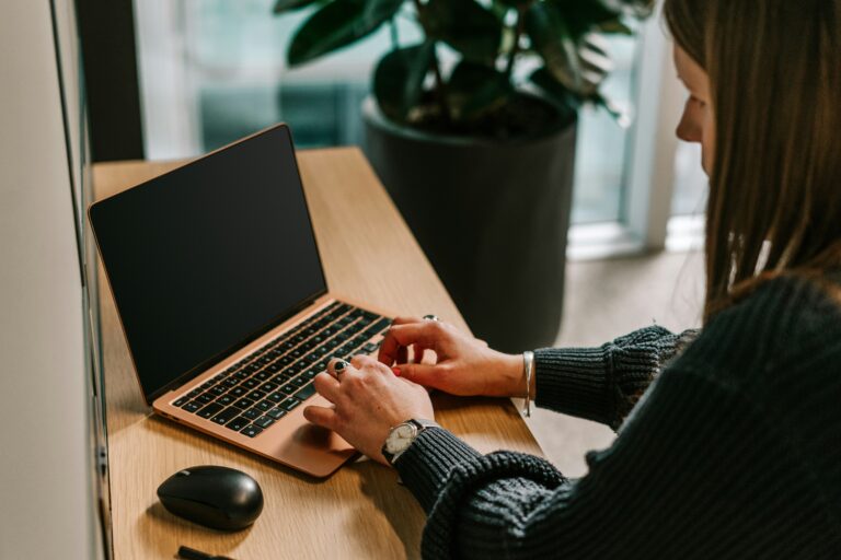 Mujer utilizando su computadora para acceder a las mejores plataformas y construir su disciplina en línea.