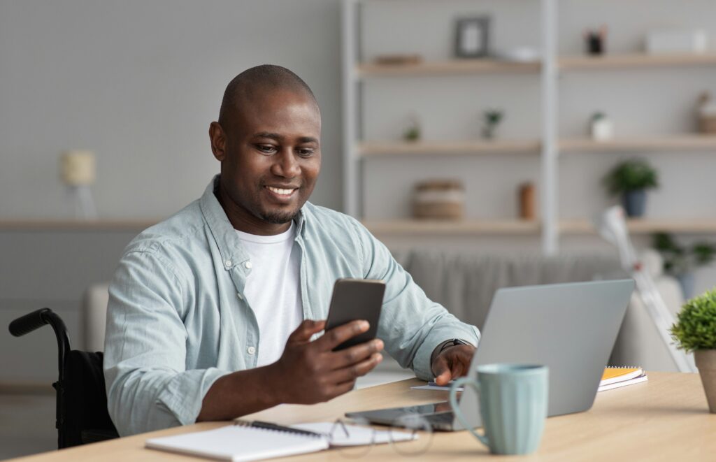 Un hombre concentrado mirando la pantalla de su teléfono móvil mientras usa una aplicación de lectura digital.