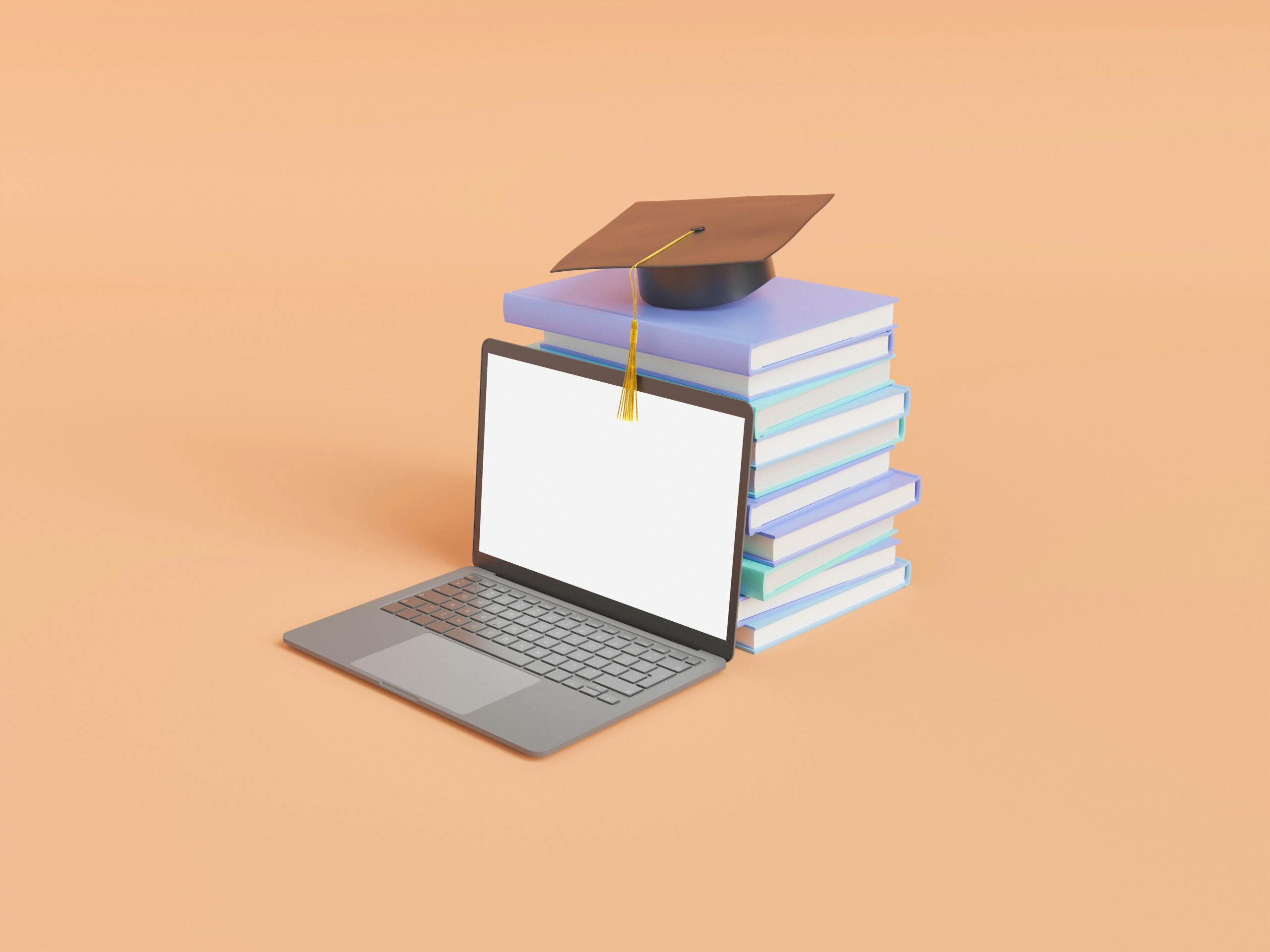 Computadora portátil al lado de varios textos de estudio y un sombrero de graduado en un escritorio.