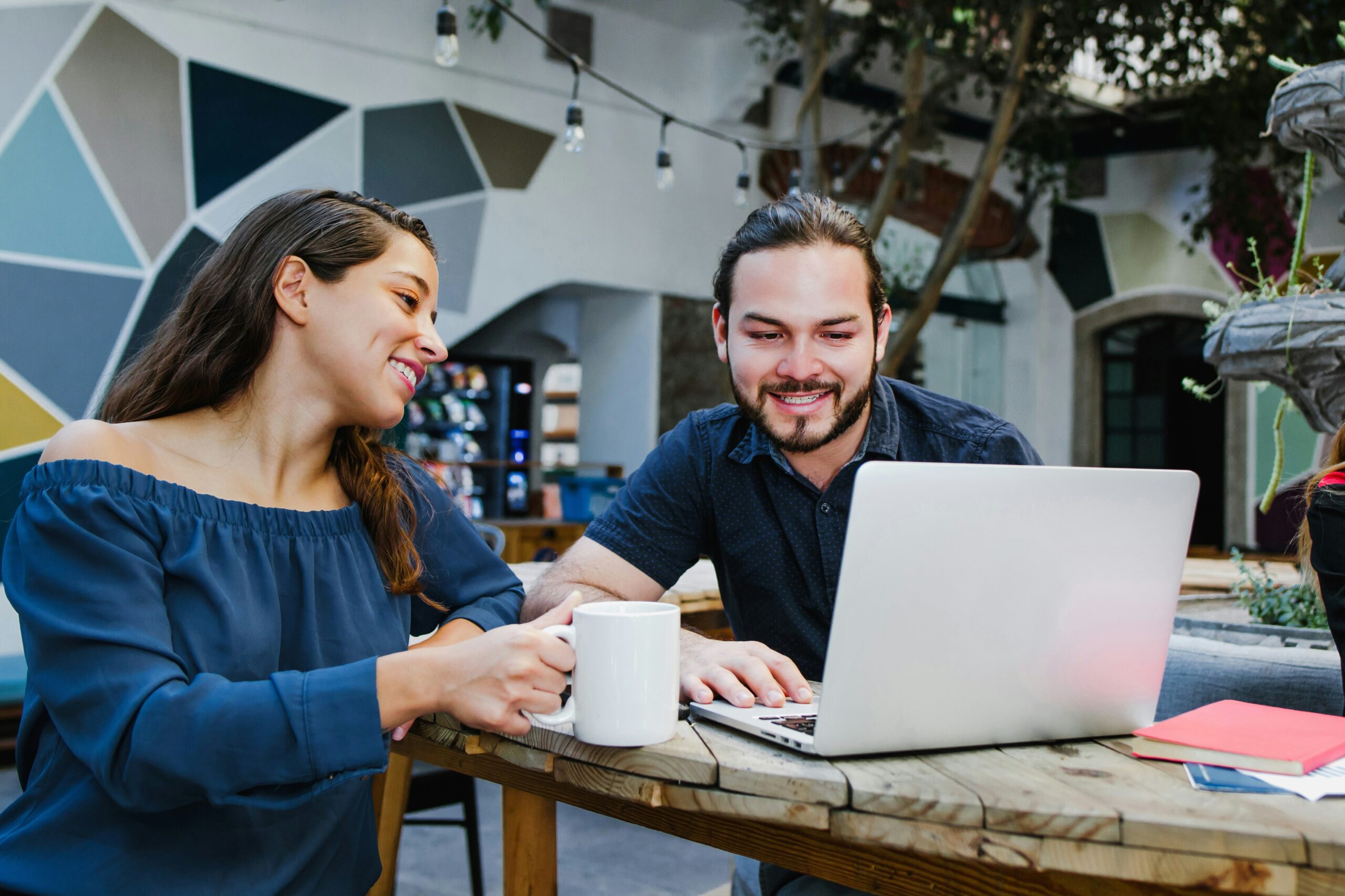 Compañeros de equipo analizando datos en una computadora dentro de un entorno de trabajo colaborativo y moderno.