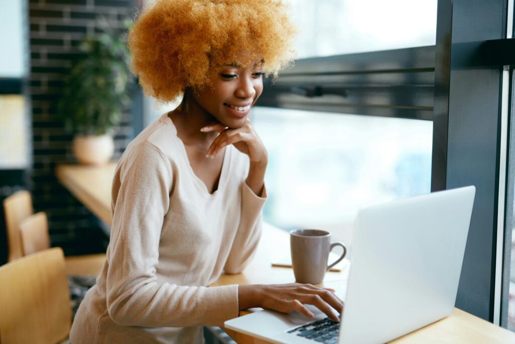 Mujer concentrada estudiando y escribiendo la definición de metas para sus proyectos en un cuaderno.