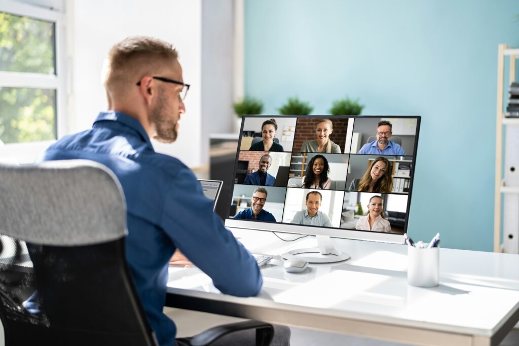 Un hombre trabajando en home office como freelancer mientras participa en una reunión online.
