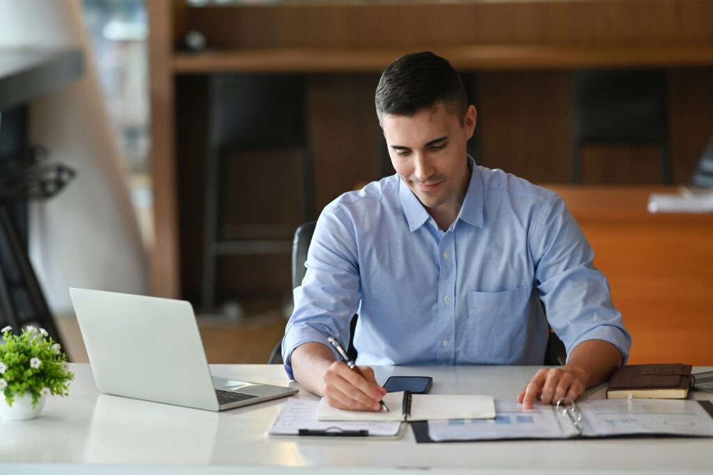 Hombre concentrado analizando y definiendo las actividades y estrategias en su calendario de planificación mensual.
