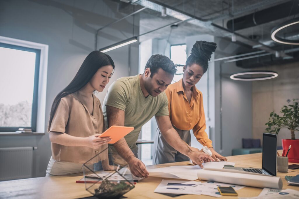 Tres personas definiendo los objetivos de un proyecto que están creando.