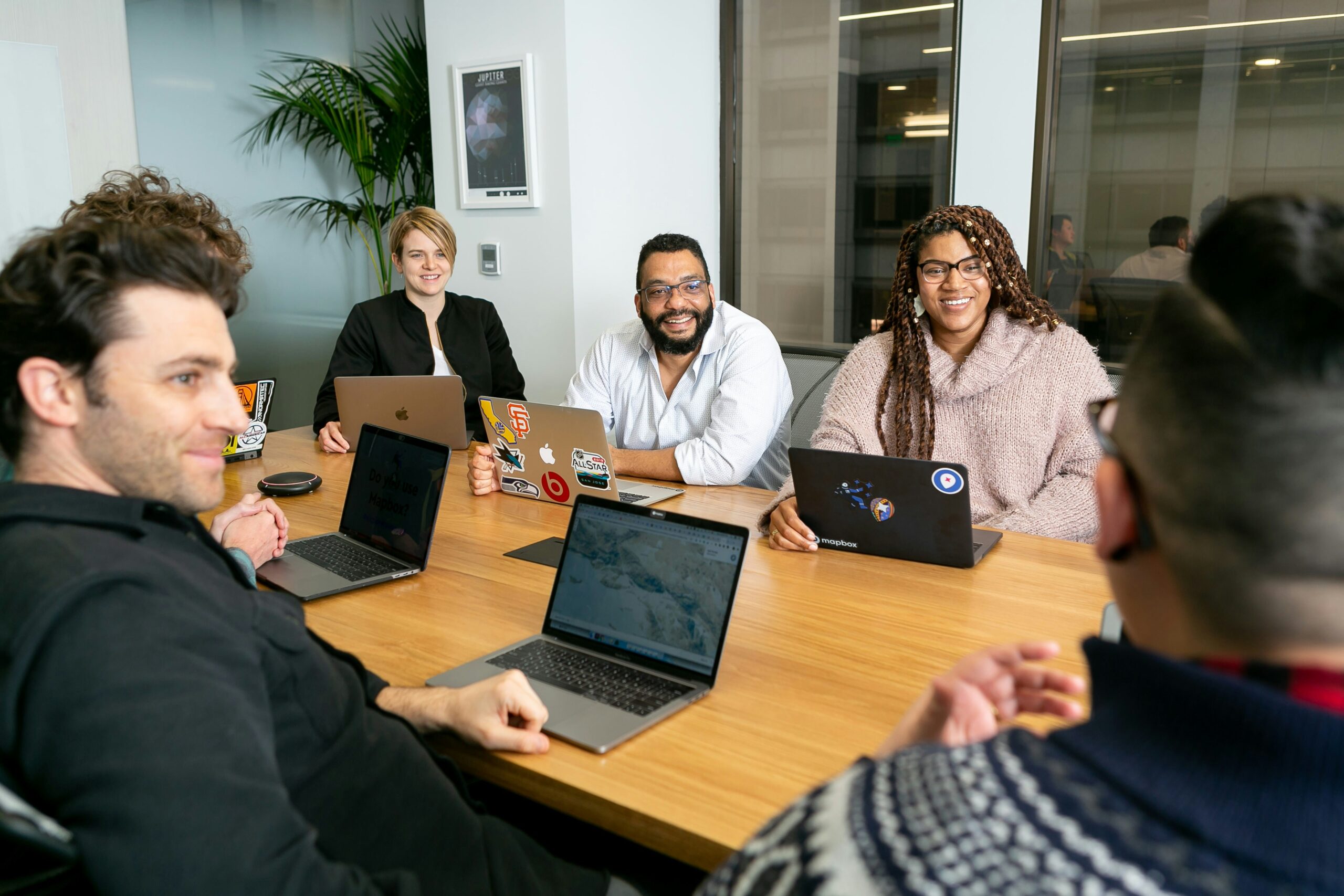 Un equipo de trabajo colaborando en una reunión para definir y organizar las tareas más importantes de su proyecto actual.